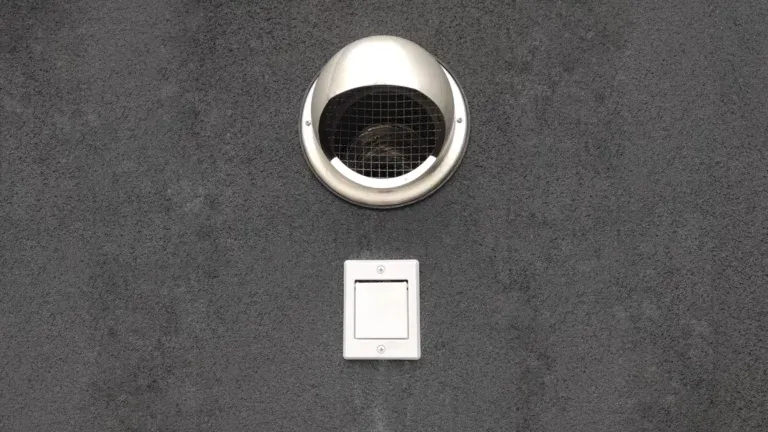 Grille de rejet extérieur de la centrale d'aspiration, installée en façade d'une maison à Luzarches