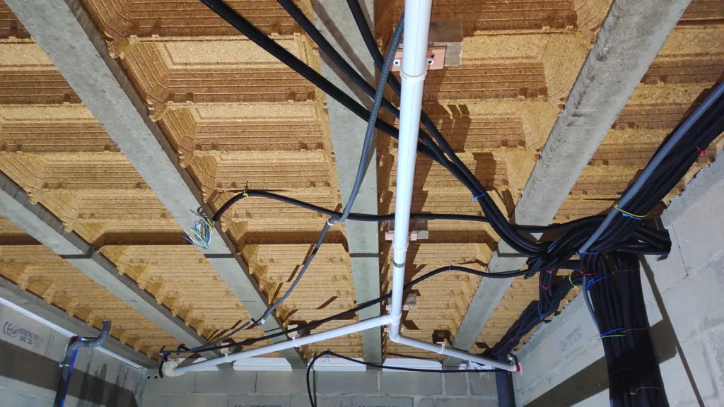 Réseau PVC d'aspiration centralisée posé au plafond d'un garage, avant la pose du faux plafond
